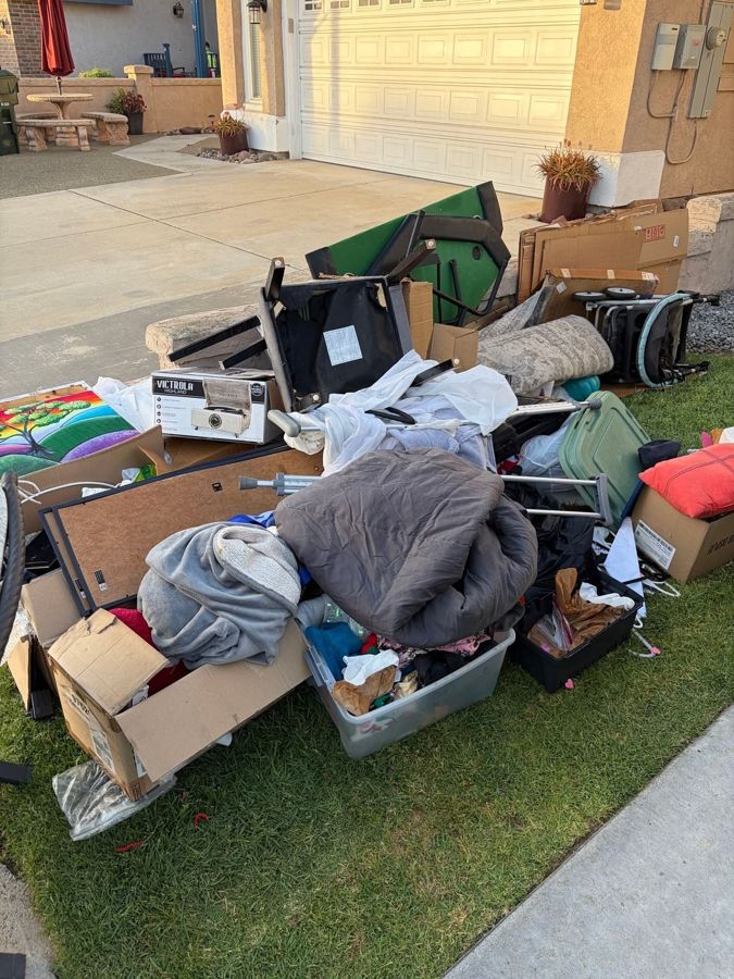 Boxes, bedding and household items piled on a front lawn