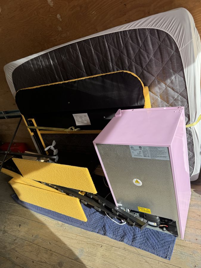 Mattress, bed frame and small fridge loaded for removal