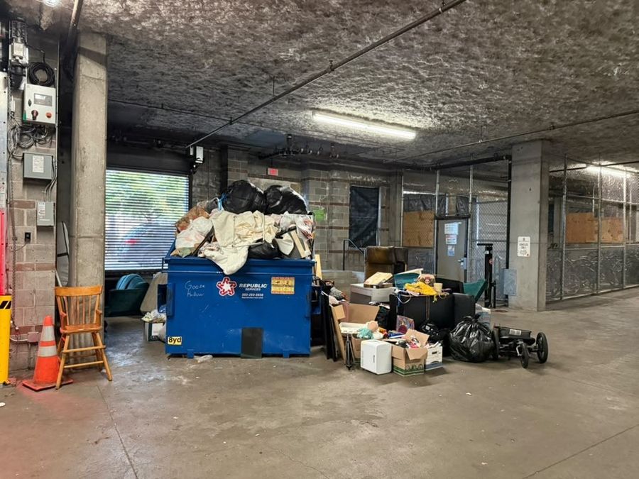 Condo parkade with bulky items left beside the dumpster