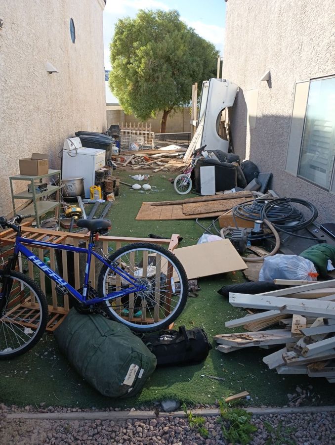 Side yard cleared of lumber, appliances, a bike and old furniture